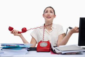 Stressed secretary answering the phones against a white background