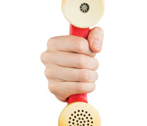 Hand holding red telephone receiver
