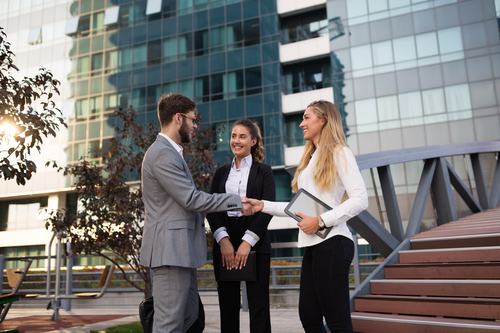 Businesspeople shaking hands outdoors