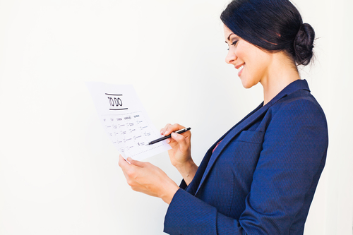 Woman checking office tasks as completed in to-do list