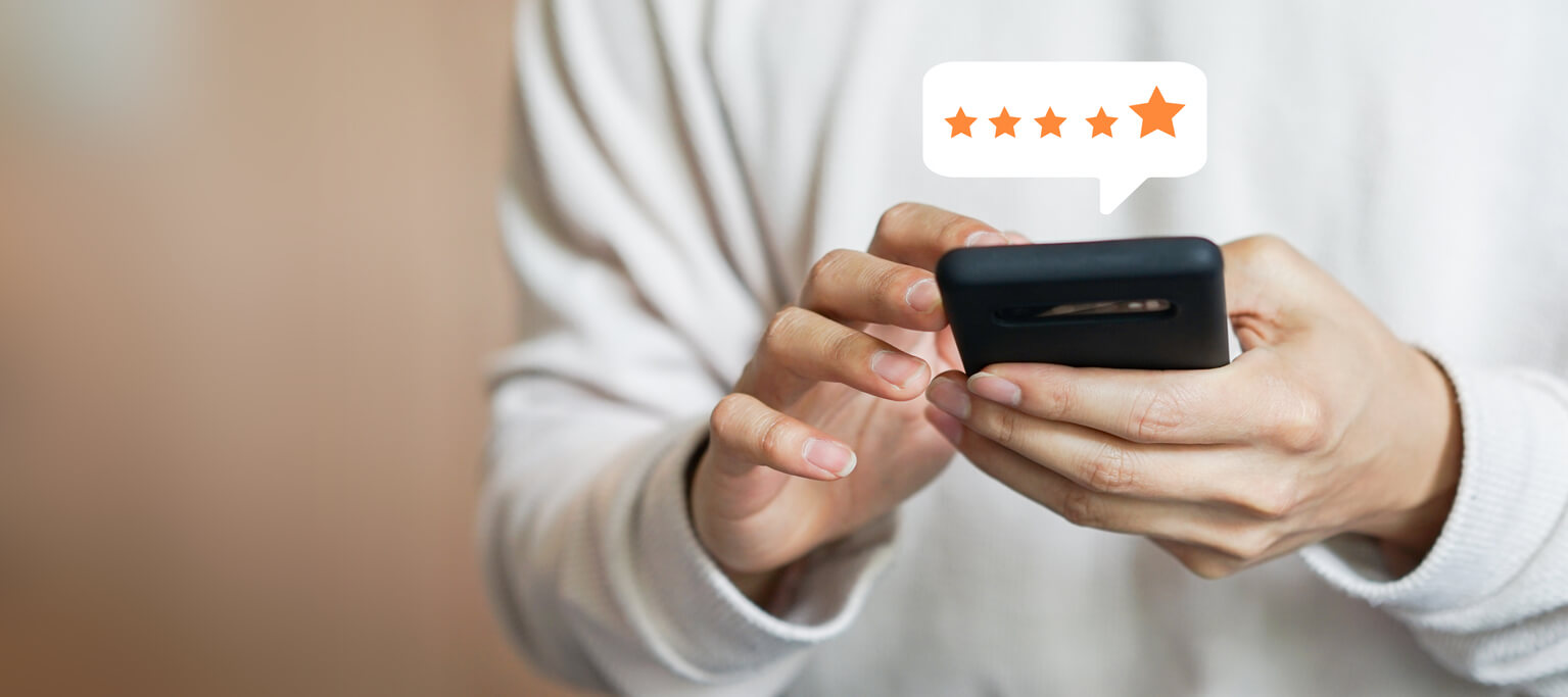 Close Up on Customer Man Hand Pressing On Smartphone Screen With Gold Five Star Rating Feedback Icon