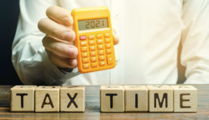 Wooden Blocks With the Word Tax Time and Taxpayer With the Inscription 2021 on the Calculator.
