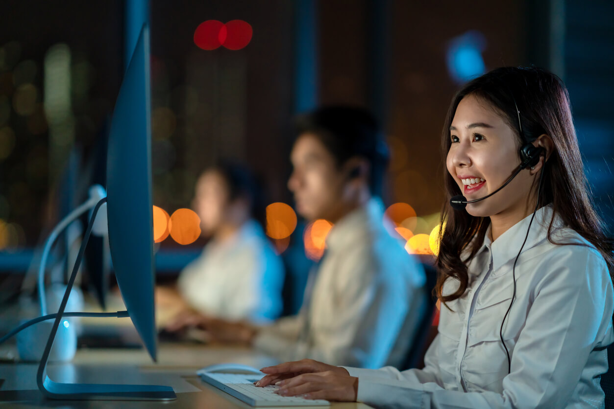 Young Happy Asian Woman Call Centre Sitting in Office at Night Shift 