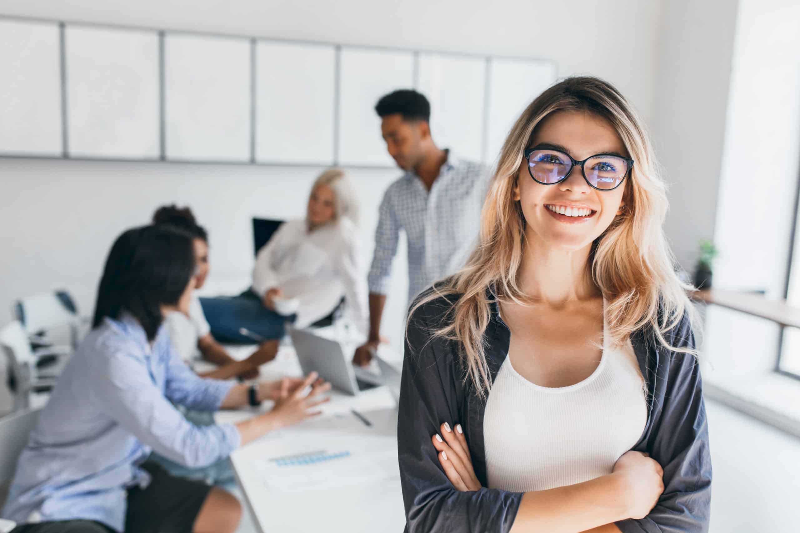 Business Woman Smiling With Office Workers In Background