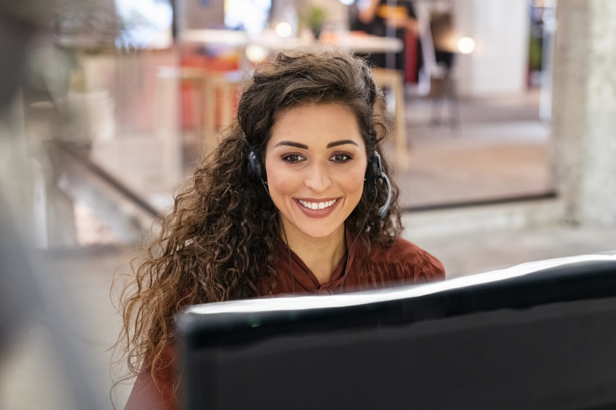 Woman Customer Support Operator With Headset Working on Computer.