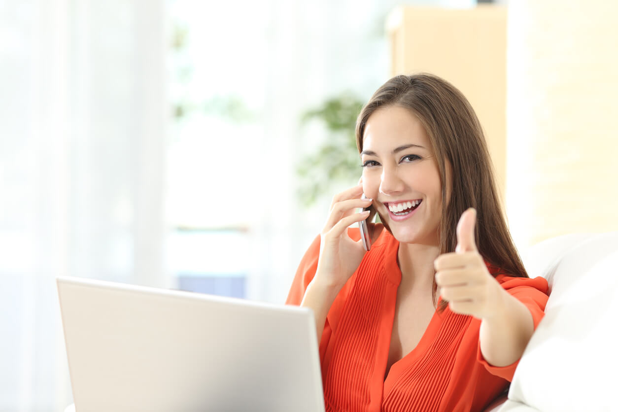 Business Woman Giving A Thumbs Up At Her Desk