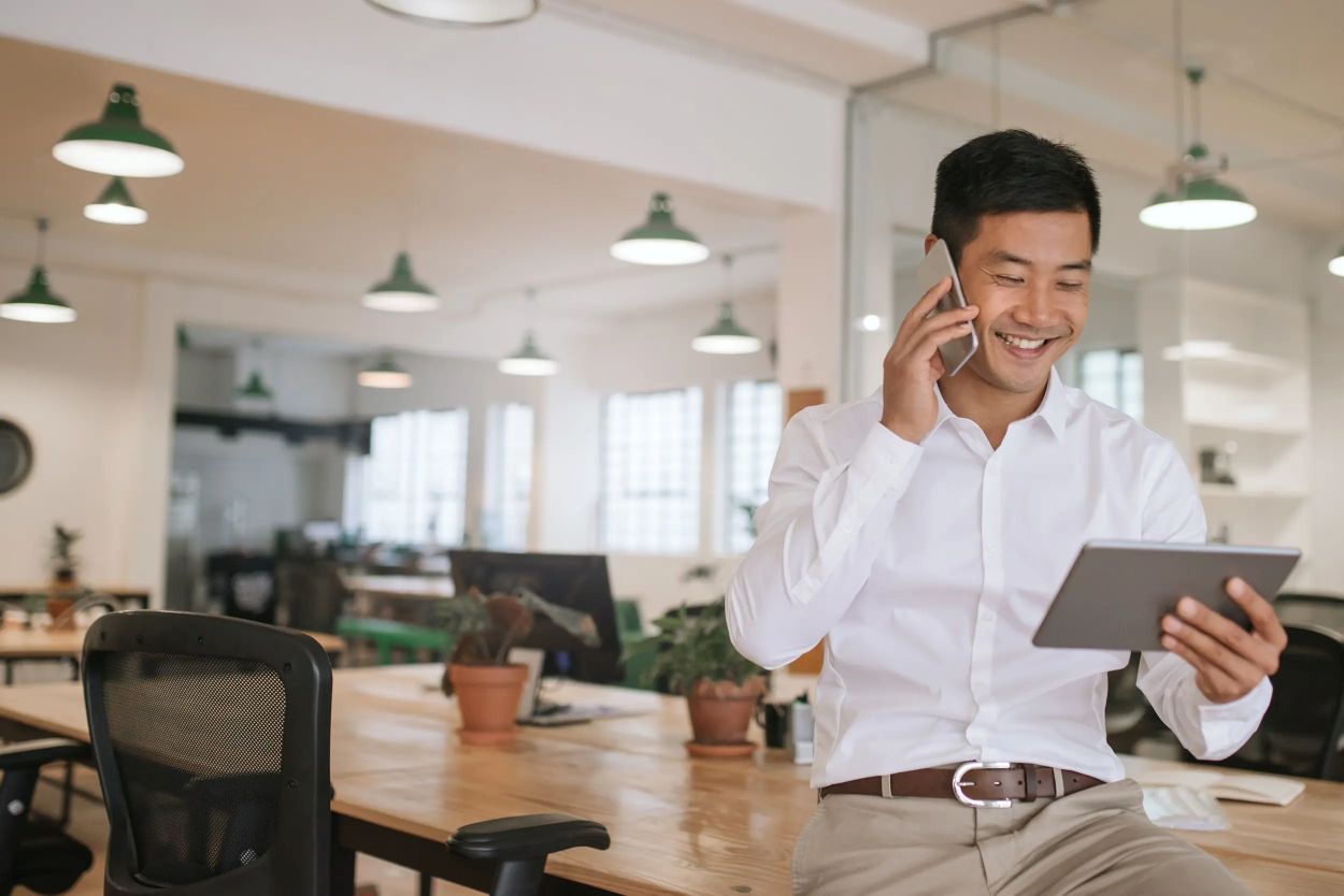 Person on the Phone Holding a Tablet